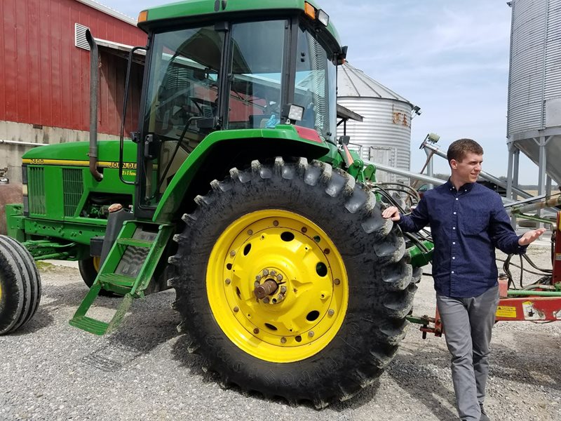 Brock Cousino standing next to tractor